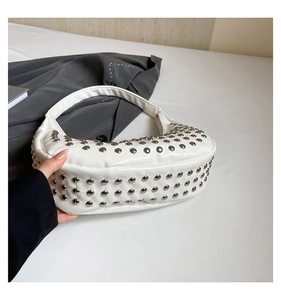 Detailansicht der weißen Tasche mit silbernen Punk-Nieten und matter PU-Ledertextur