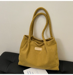 Detailed close-up of the vintage corduroy tote bag featuring a stitched fashion leather label