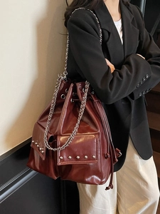 Waterproof burgundy leather bucket bag with silver chain straps and rivet pockets