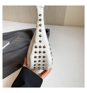 Detail der weißen Punk-Einkaufstasche mit dichten silbernen Metallnieten auf glattem Leder