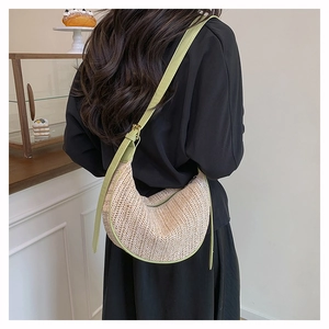 Dettaglio borsa a mezzaluna intrecciata con finiture in pelle verde chiaro sulla modella