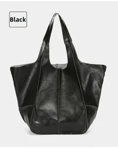 Detail of black soft leather tote bag showing vertical stitching and smooth texture