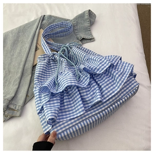 Detailed view of blue gingham tote bag with layered ruffle design and drawstring closure