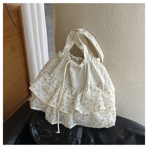 Detalle de los volantes florales y la textura de lona en este bolso tote con cordón