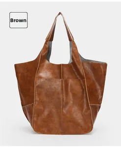 Detail view of the brown soft leather tote bag with retro texture and visible stitching