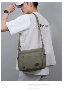 Detail of olive green canvas messenger bag featuring multiple pockets and durable straps