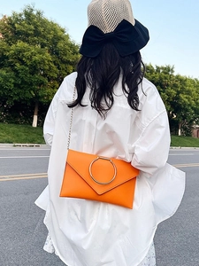 Pochette enveloppe orange chic avec poignée en anneau doré et bandoulière chaîne
