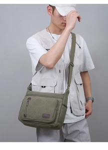 Army green canvas messenger bag worn by male model for casual commuting and travel use