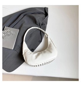 Detailansicht der weißen Punk-Tasche mit silbernen Nieten am Boden und mattem Leder-Finish