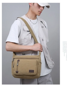 Men's khaki canvas crossbody bag with multiple zip pockets shown in a lifestyle model shot