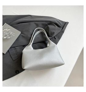Detail of silver pebble grain leather underarm bag with a stylish hollowed rivet design