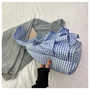Detail view of blue checkered canvas tote bag with ruffled edges and drawstring closure