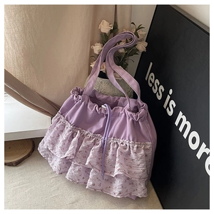 Detalle del bolso tote de gasa violeta con volantes florales y cierre de cordón ajustable
