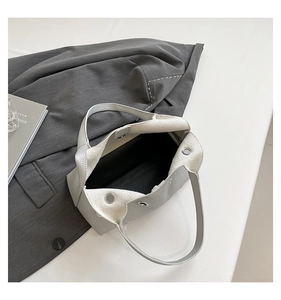Detail view of the interior compartment and magnetic silver clasp of the beige rivet bag