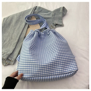 Detailed view of the blue and white checkered canvas tote bag with drawstring closure