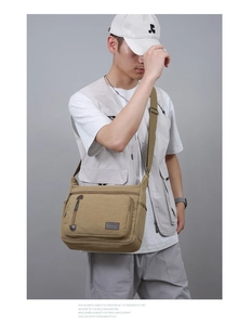 Close-up of a khaki canvas messenger bag on a male model with vintage leather accents