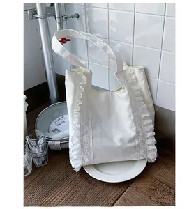 Detailed shot of white canvas tote bag featuring delicate lace ruffled edges and yellow lining