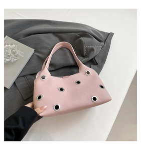 Detailed view of pink lychee leather bag with silver metal eyelets and modern rivet design