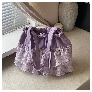 Detalle del bolso tote morado con volantes florales y práctico cierre de cordón