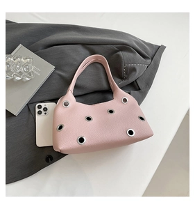 Detailed macro view of pink litchi grain leather texture and silver metal eyelets