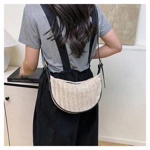 Dettaglio della borsa a tracolla a mezzaluna intrecciata con finiture in pelle nera