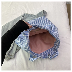Detail view of the blue gingham tote bag interior with pink lining and zip pocket