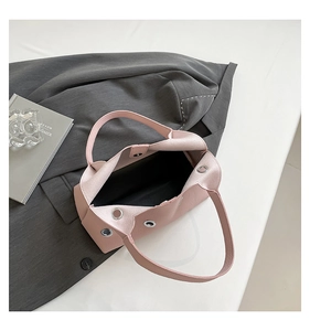 Detailed view of pink pebble leather bag with magnetic closure and metallic eyelets