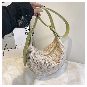 Dettaglio della borsa intrecciata beige con finiture in ecopelle verde chiaro e tracolla
