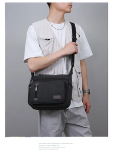 Men's black canvas messenger bag with double zippers and adjustable shoulder strap