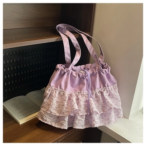 Detalle de bolso tote floral morado con cordón y dobladillo con volantes en estante