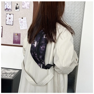 Détail du sac bandoulière avec imprimé crâne et fleurs et sangle en nylon ajustable