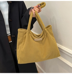 Detail of ginger corduroy tote bag featuring a square fashion leather label and soft texture