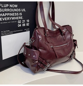 Detail view of burgundy tote bag showing silver rivets and glossy PU leather texture