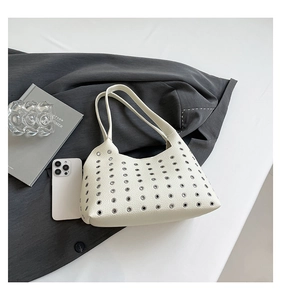Detail of white lychee leather shoulder bag with silver rivet eyelet decorations