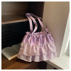 Detalle del bolso tote con volantes florales y cordón morado en una estantería