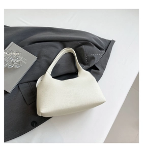 Close-up of off-white minimalist underarm bag featuring premium lychee grain leather texture
