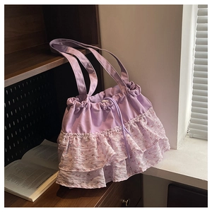 Detalle del bolso tote de gasa morada con volantes de encaje floral y cordón ajustable