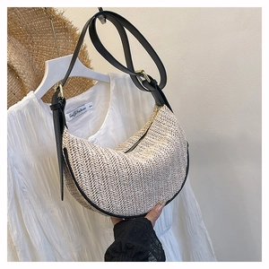 Dettaglio borsa a mezzaluna intrecciata beige con tracolla in pelle nera per stile estivo