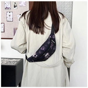 Détail de l'imprimé crâne gothique et fleurs mauves sur le sac banane avec sangle nylon