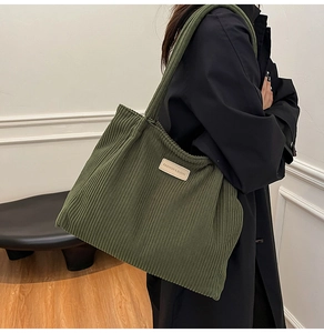 Detail shot of the olive green corduroy tote bag featuring a stitched fashion label