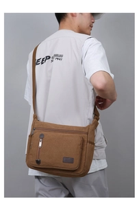 Detailed side view of brown canvas messenger bag with leather accents on a male model
