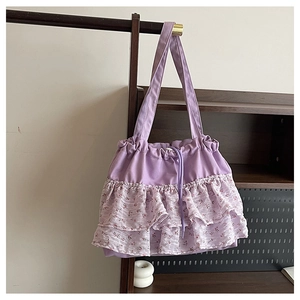 Detalle de bolso tote de lona morada con volantes florales y cierre de cordón