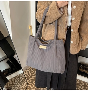 Gray corduroy tote bag with fashion label shown on model for casual winter style
