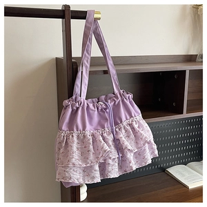 Detalle del bolso tote de lona morada con volantes florales y cierre de cordón