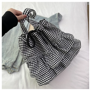 Detail view of black and white checkered canvas tote with ruffled layers and drawstring closure