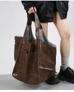 Macro shot of dark brown vintage leather tote bag with large side pocket detail