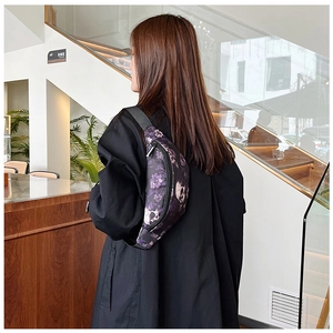 Détail d'un sac bandoulière avec imprimé crâne floral violet porté par un mannequin