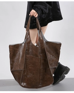 Detailed close-up showing the soft vintage texture and retro brown leather of the tote bag