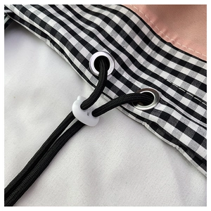 Close-up of black and white gingham tote bag with pink fabric and drawstring toggle
