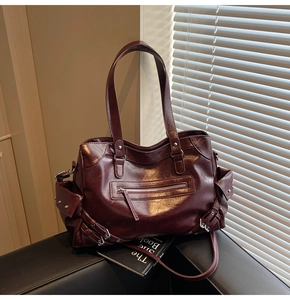 Close-up of deep wine red retro leather tote bag featuring metal rivet details and pockets